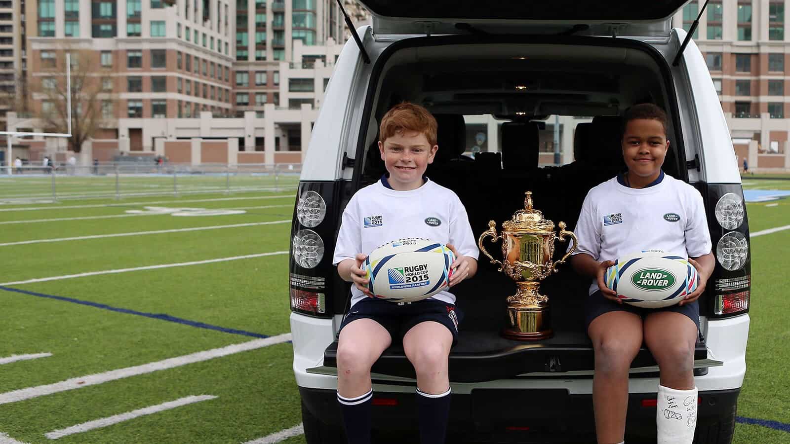Children sitting with trophy in Range Rover