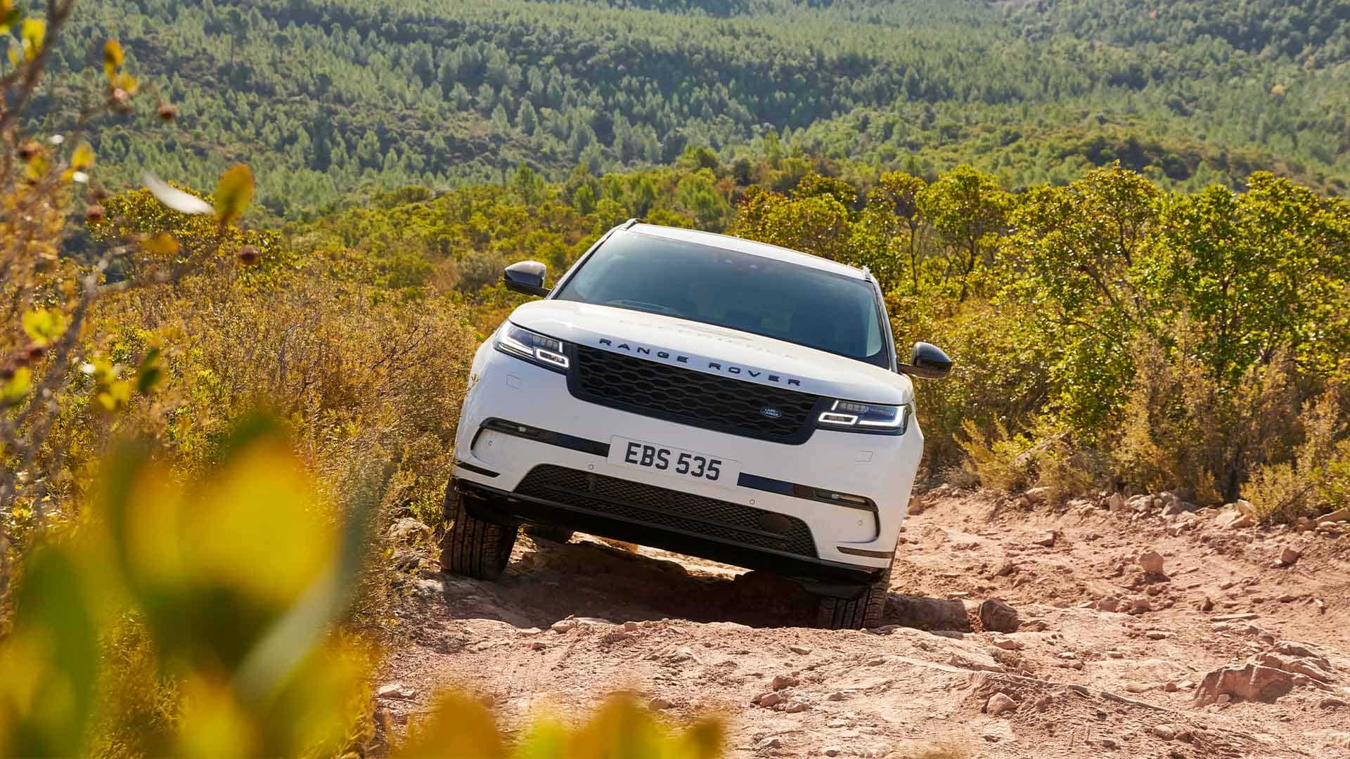 White Velar driving through muddy terrain