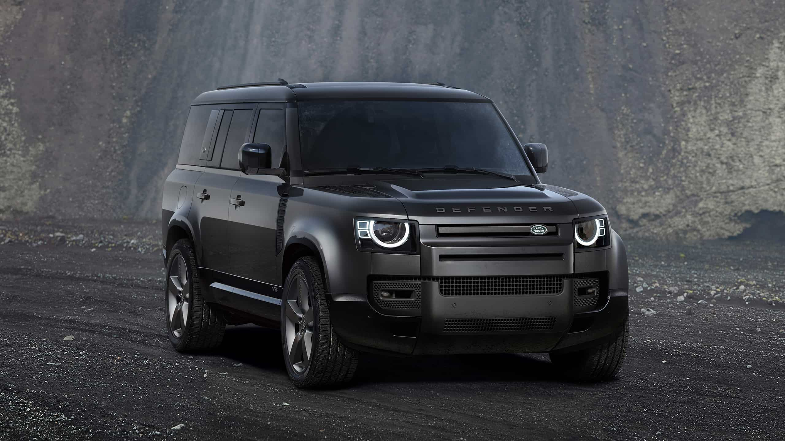 Parked defender on off-road and stone hill background